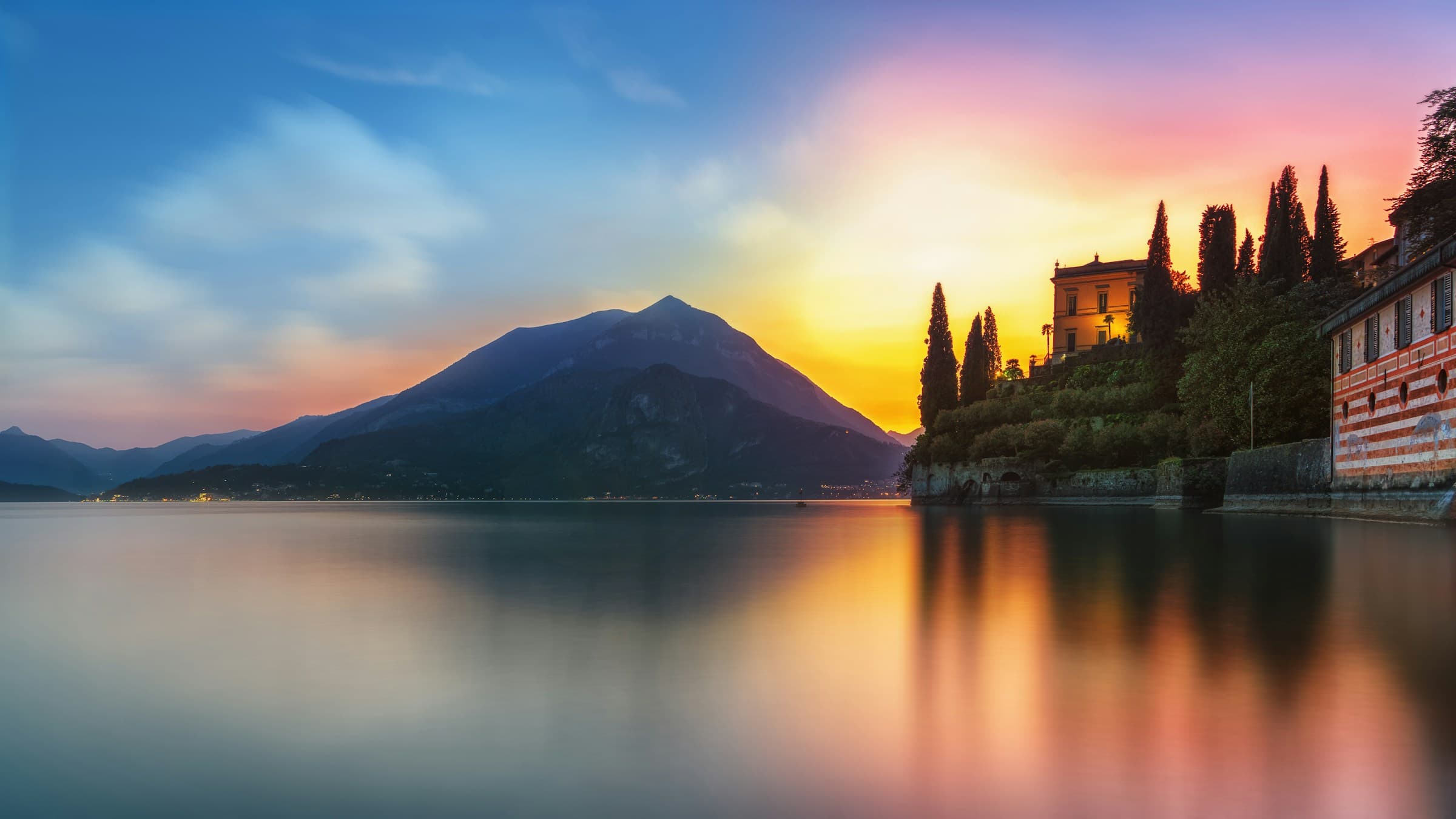 Sunset over Lake Como with mountains reflected in still water